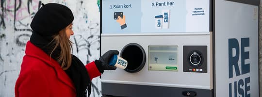 Person returning a reusable cup at a TOMRA collection point in Aarhus Denmark